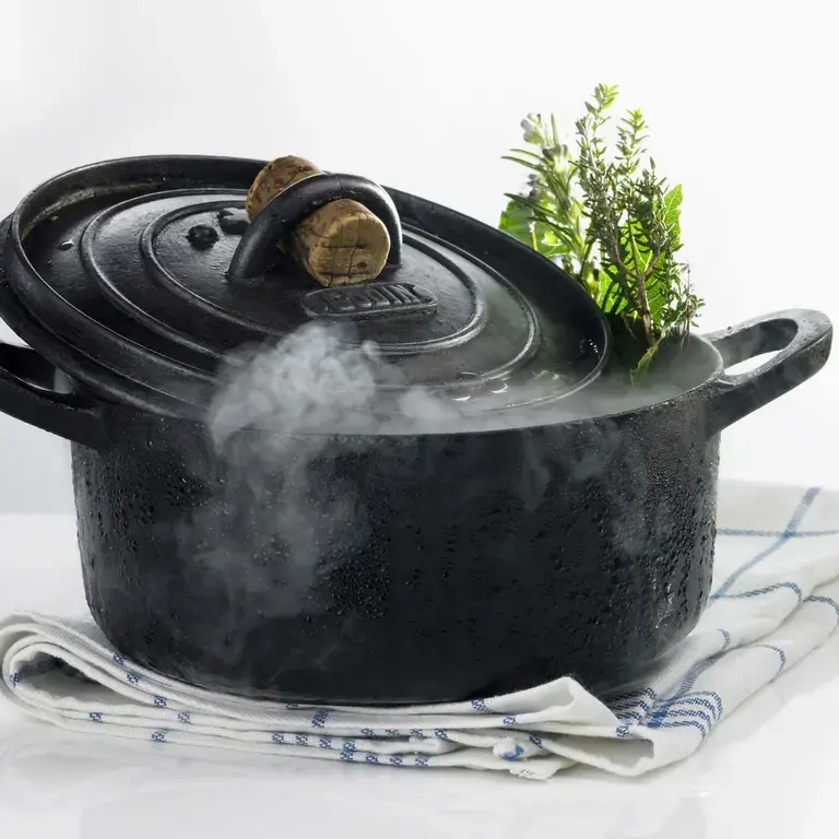 A steaming, black Dutch oven.