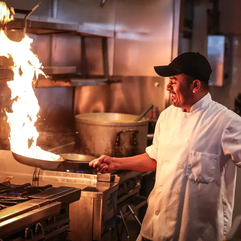 chef with pan on fire