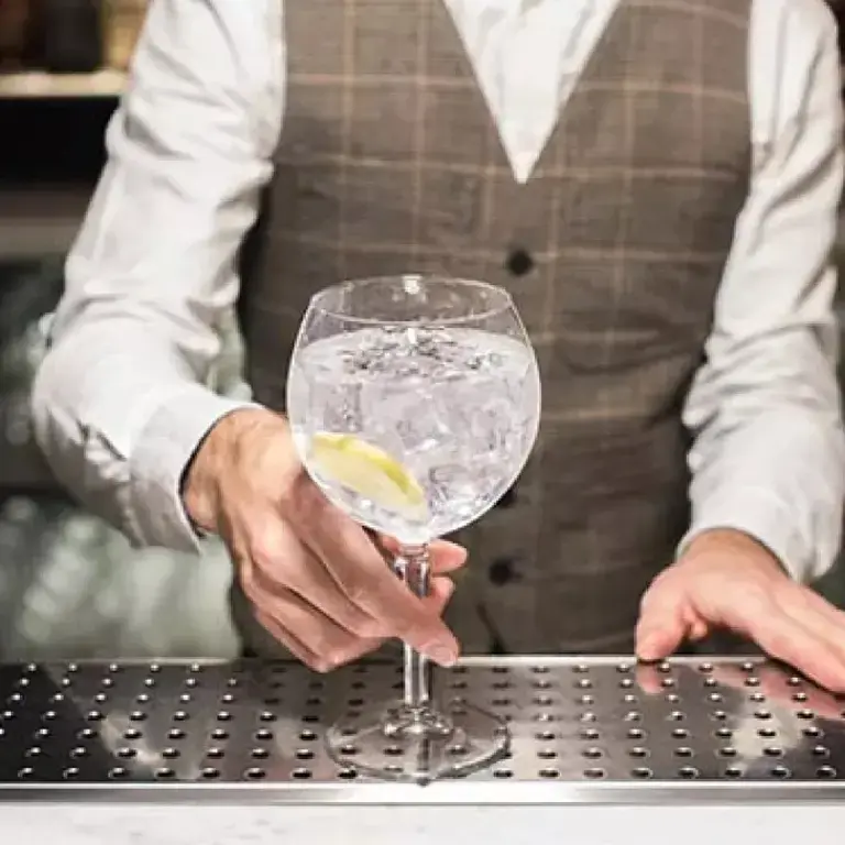 Cointreau and tonic, with a barperson holding the glass.