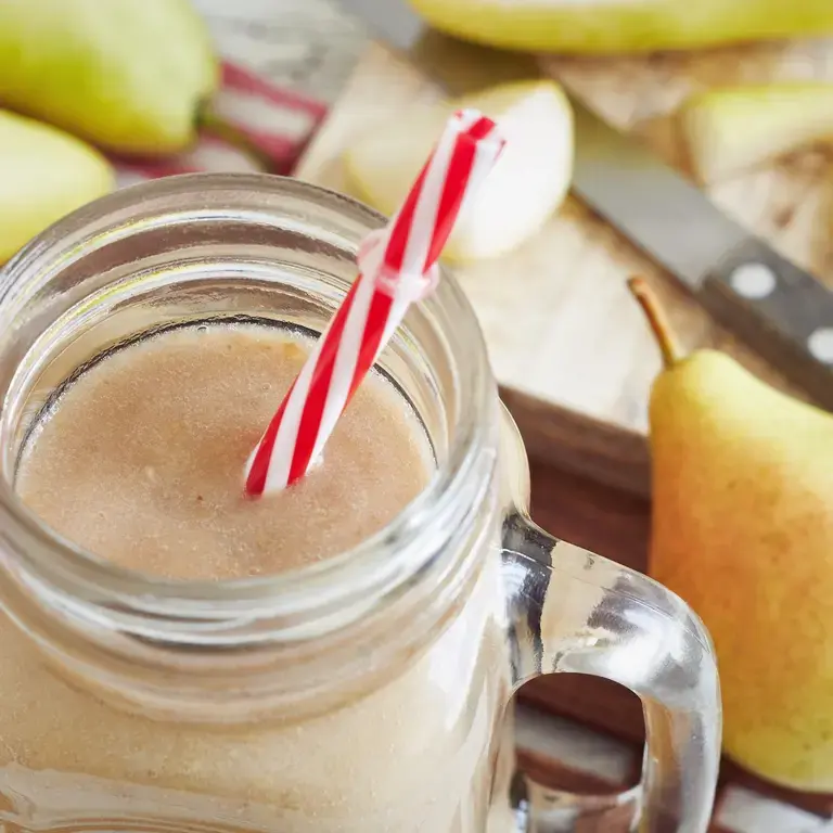 Pear smoothie with a straw.
