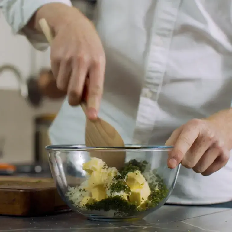 Garlic and butter being mixed in a bowl.