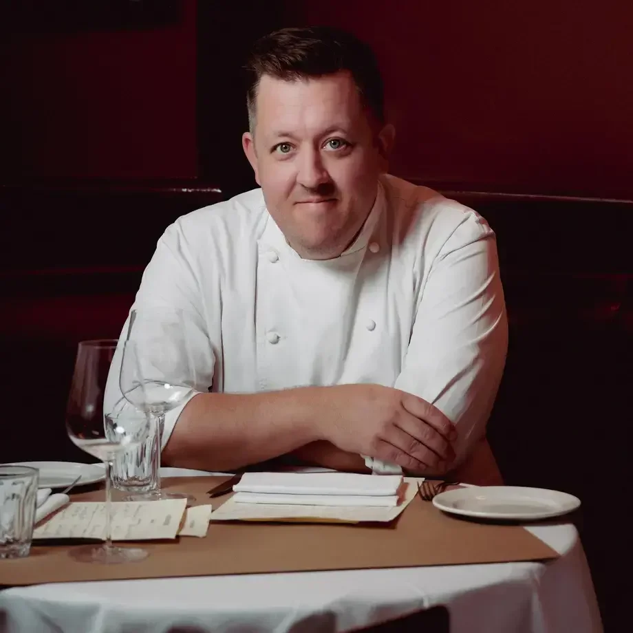 Chef Ashley Palmer-Watts at a restaurant table.