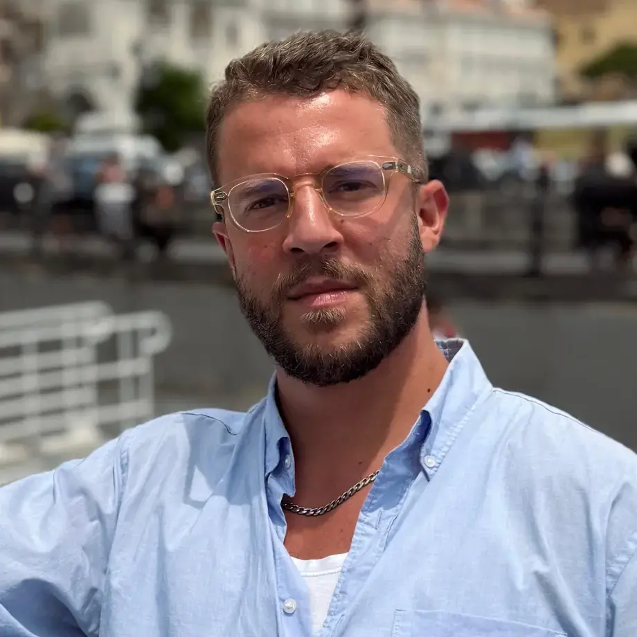 Jordon Ezra King in a blue shirt and glasses.