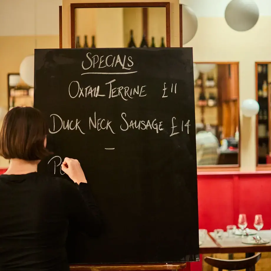 A woman writing on the blackboard at Camille.
