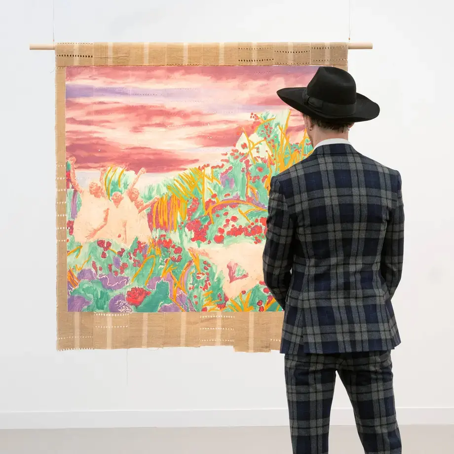 A man in a hat looking at an artwork at Frieze London 2024.