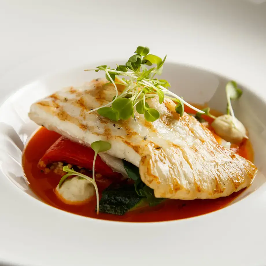 Grilled fillet of turbot with vegetables and sauce.
