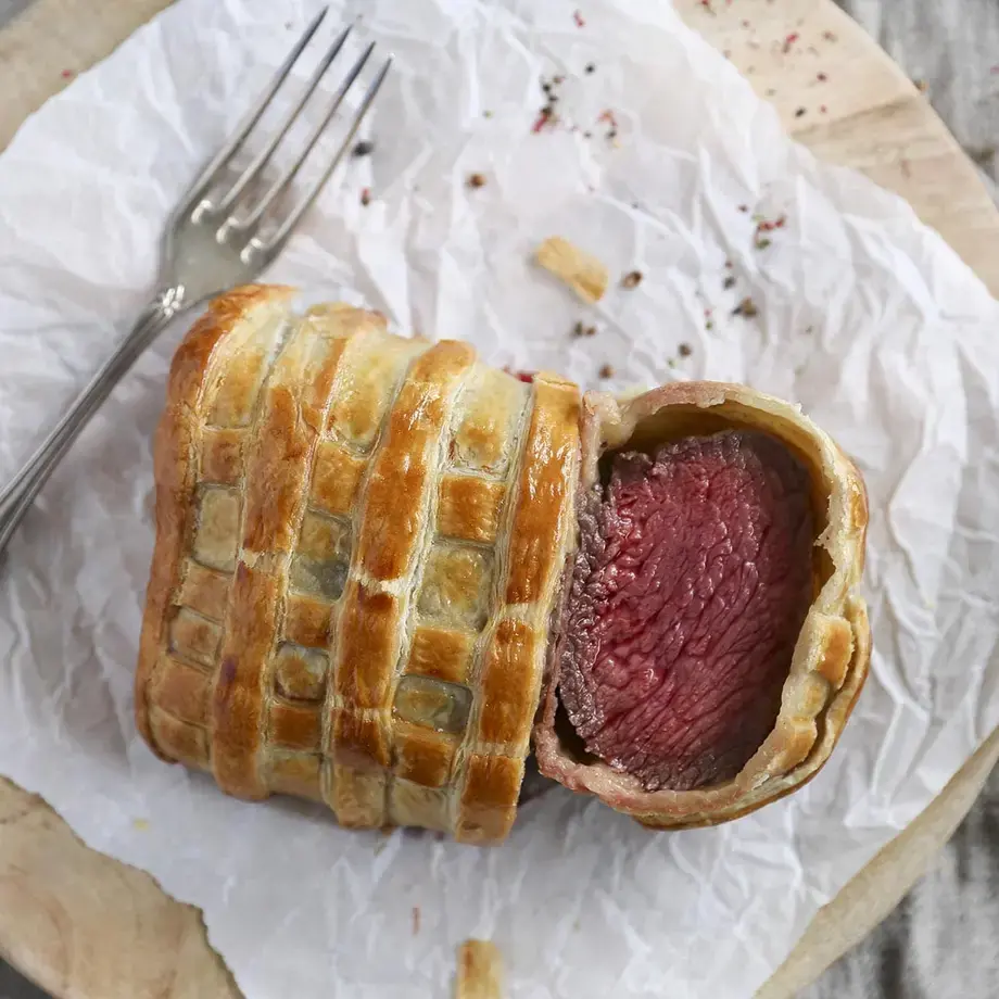 Beef Wellington, sliced on paper.