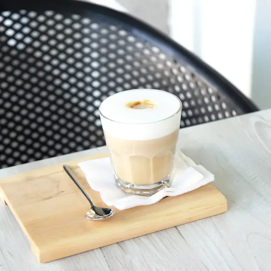 Flat white served with a teaspoon.