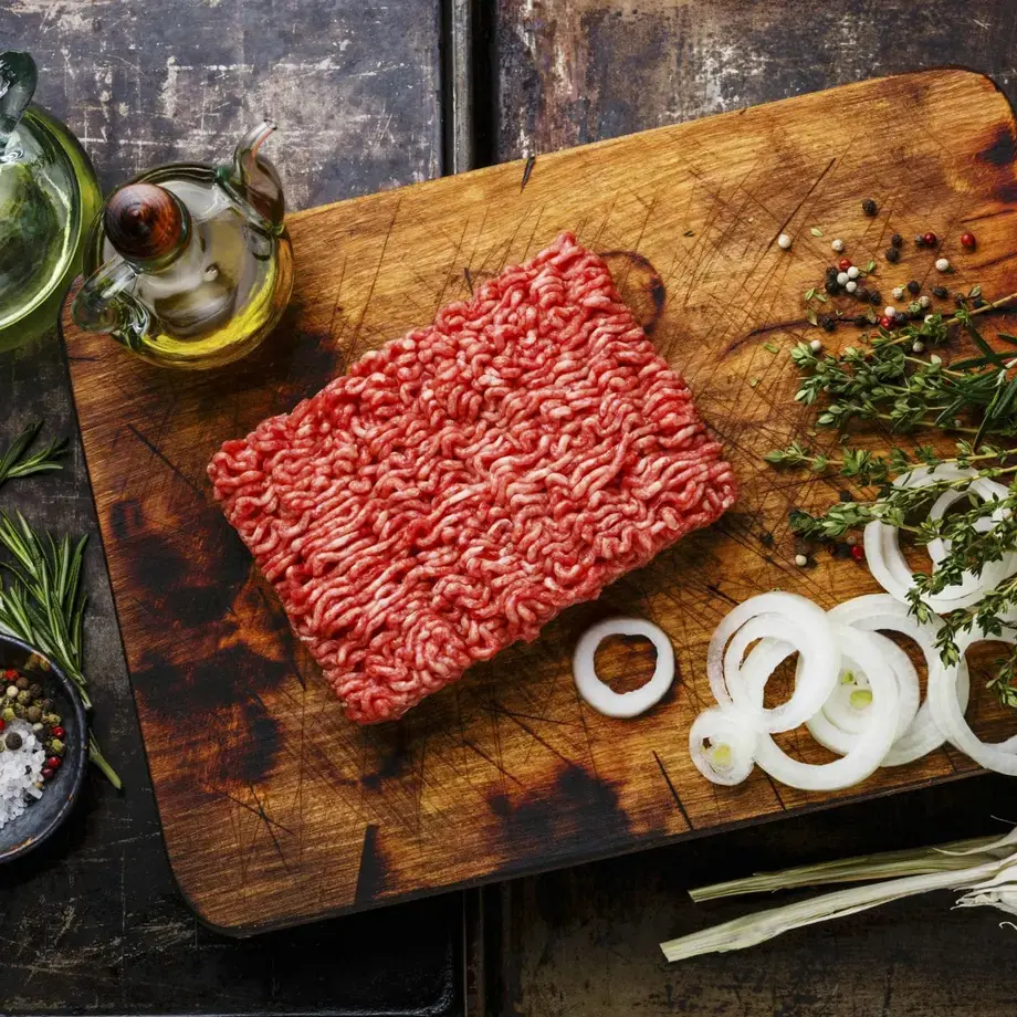 Ground beef and other ingredients on a board.