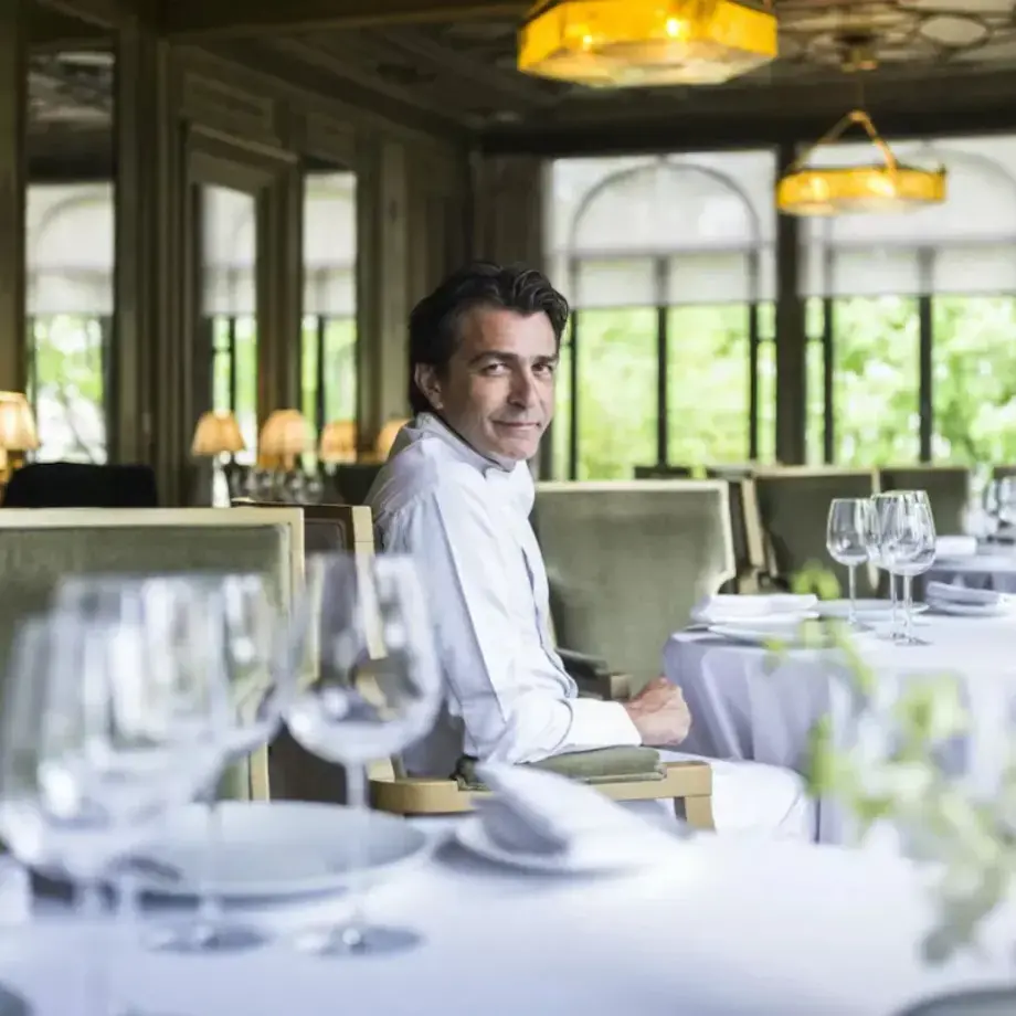 Yannick Alléno seated in an empty restaurant.