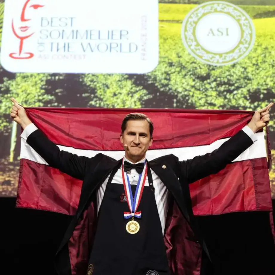 Raimonds Tomsons holding the Latvian flag.