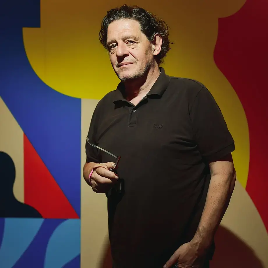 Chef Marco Pierre White in front of a colourful background.