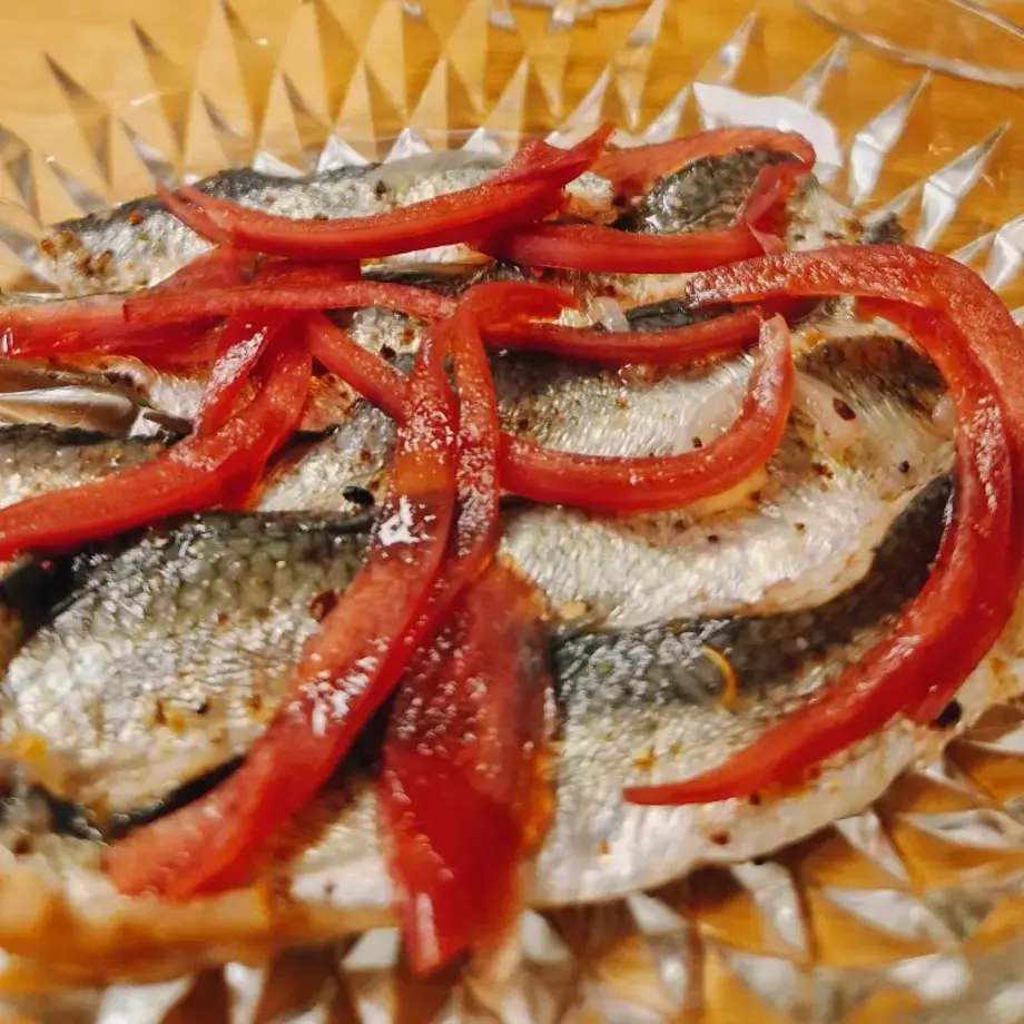 Pickled herring with allspice and onions.