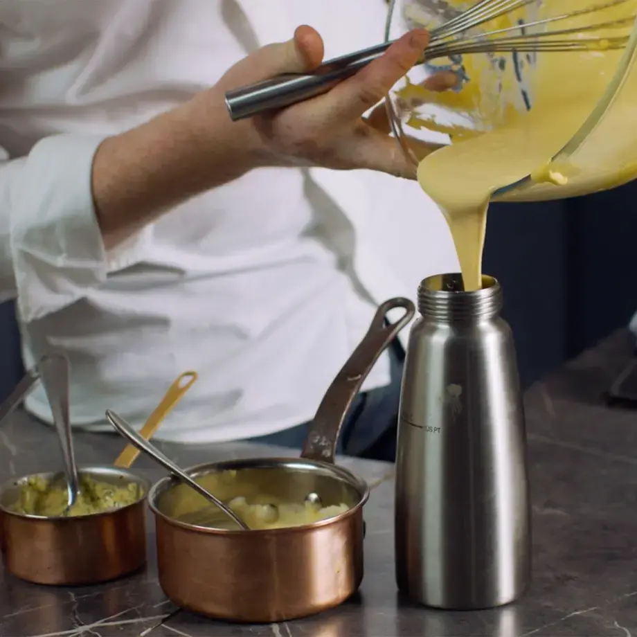 Pouring hollandaise into a siphon.