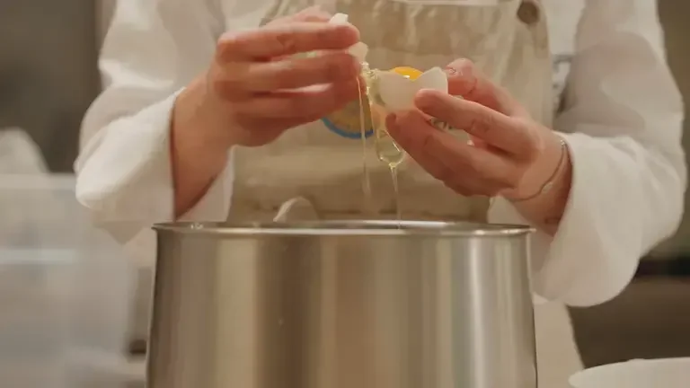 The chef breaking eggs for the meringue