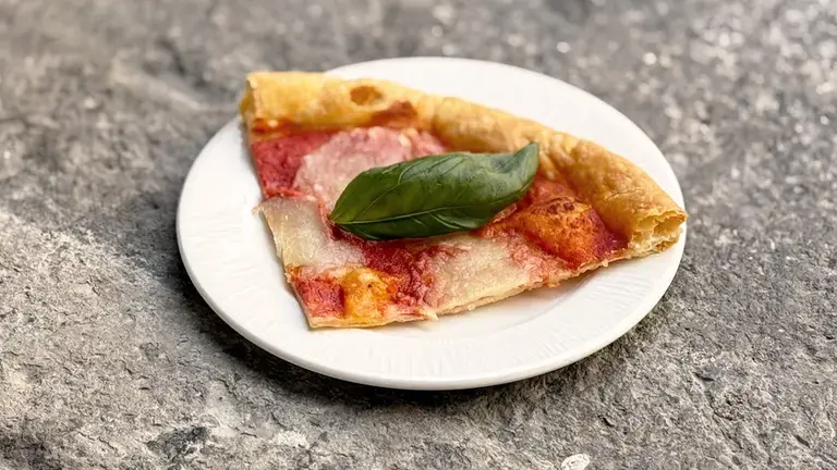 Puff pastry pizza with tomato and pesto plated