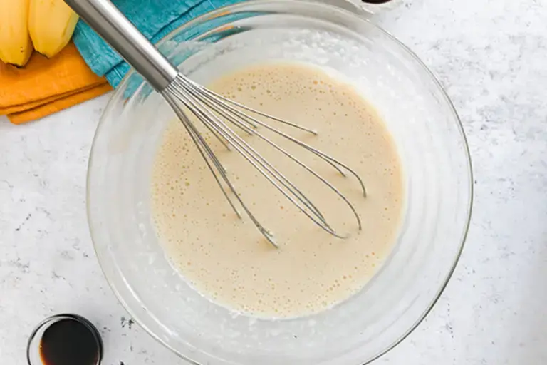 a bowl of lump free banana mix with a whisk