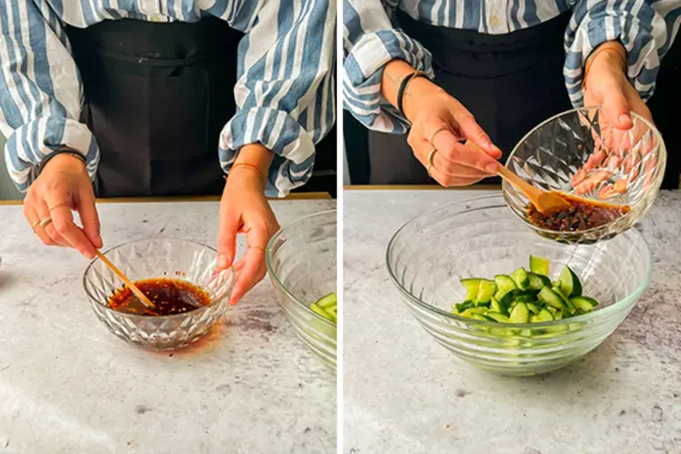 Chef mixing cucumbers and dressing.