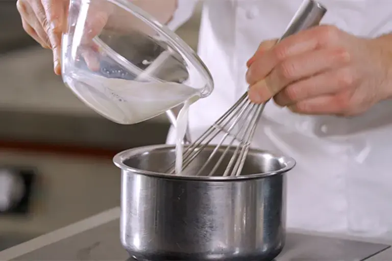 Milk being poured into a pan.