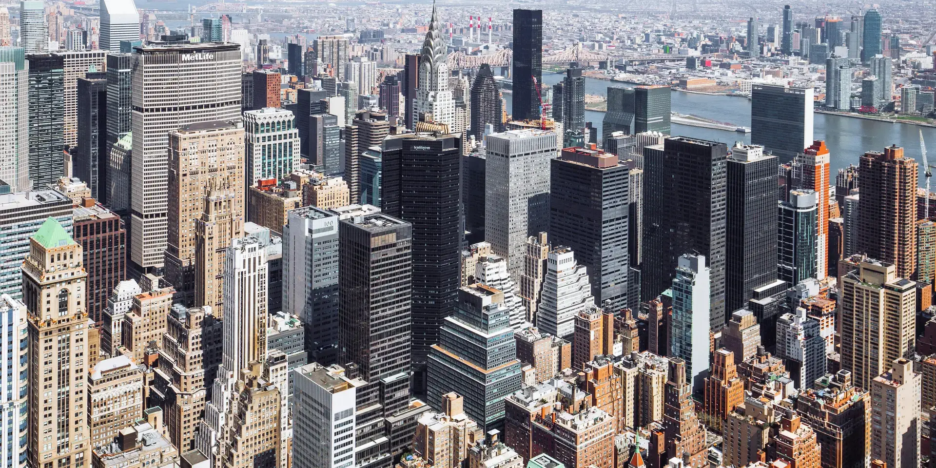 High-angle view of Manhattan’s dense skyline with prominent skyscrapers and the East River in the background