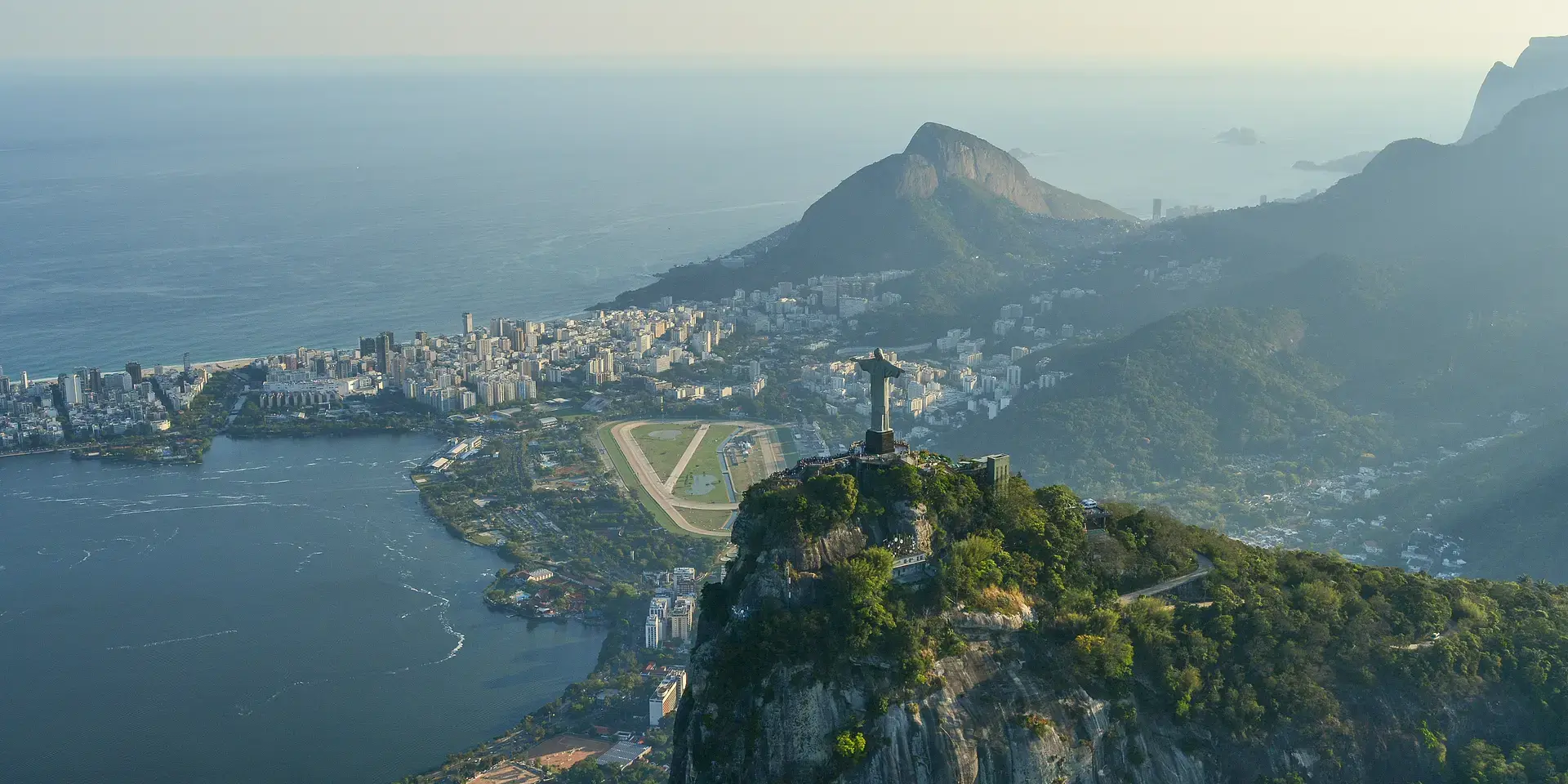 Iconic Christ the Redeemer statue overlooking Rio de Janeiro, Brazil, with views of mountains, city, and the Atlantic Ocean