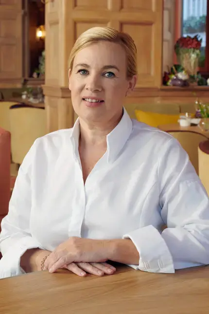 Chef Hélène Darroze sitting in a restaurant dining room.
