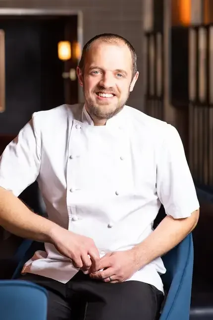 Chef James Knappett sitting on a chair.
