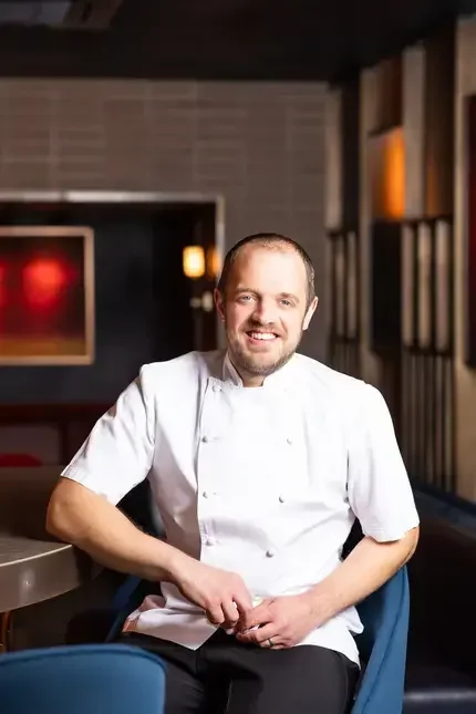 Chef James Knappett sitting on a chair.
