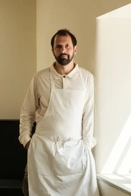 Chef Merlin Labron-Johnson standing next to a window.