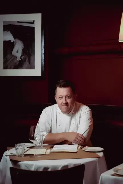Chef Ashley Palmer-Watts at a restaurant table.