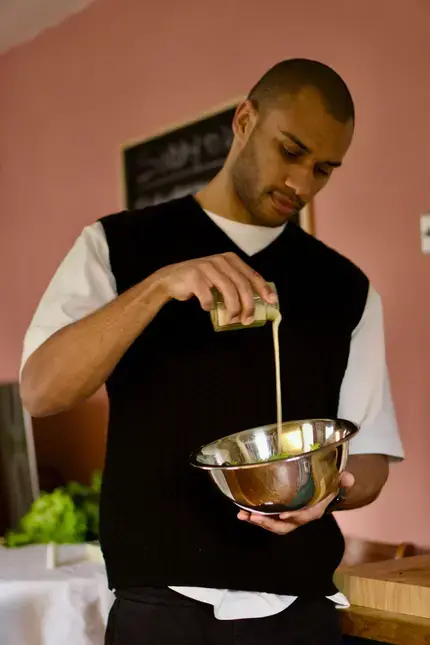 Joseph Denison Carey pouring a liquid into a mixing bowl.