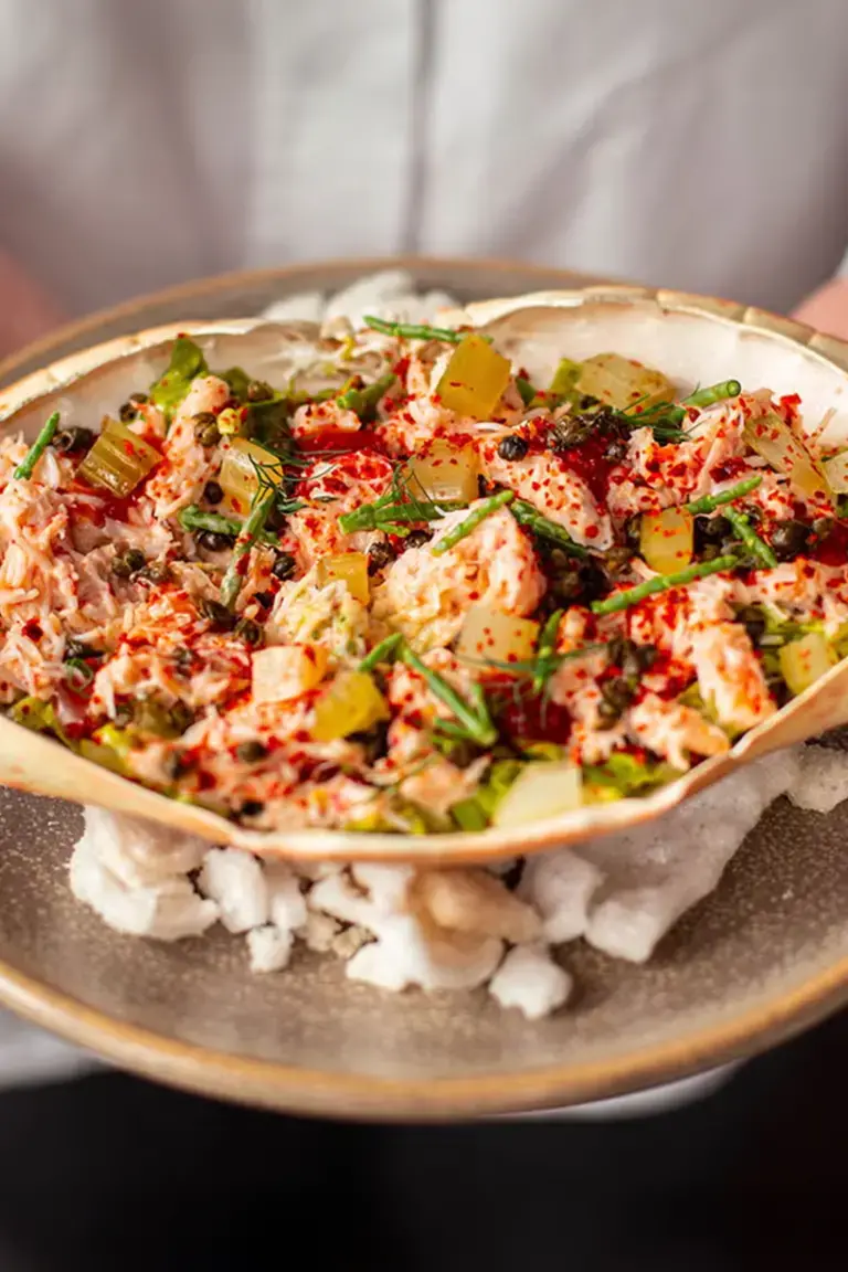 A refined crab dish served in its shell.