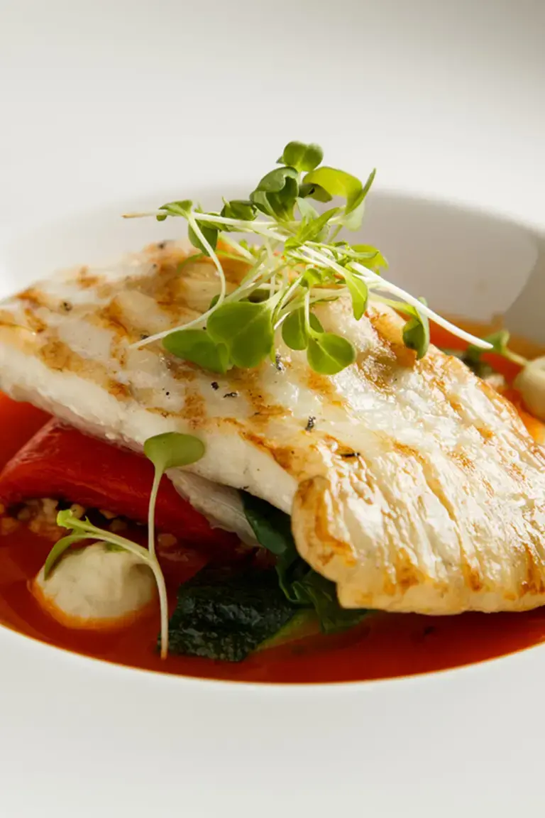 Grilled fillet of turbot with vegetables and sauce.