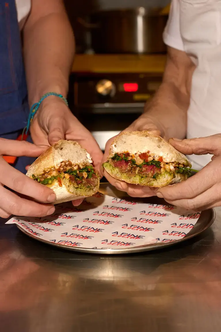 Two chefs holding the Fine Collab Sandwich in London.