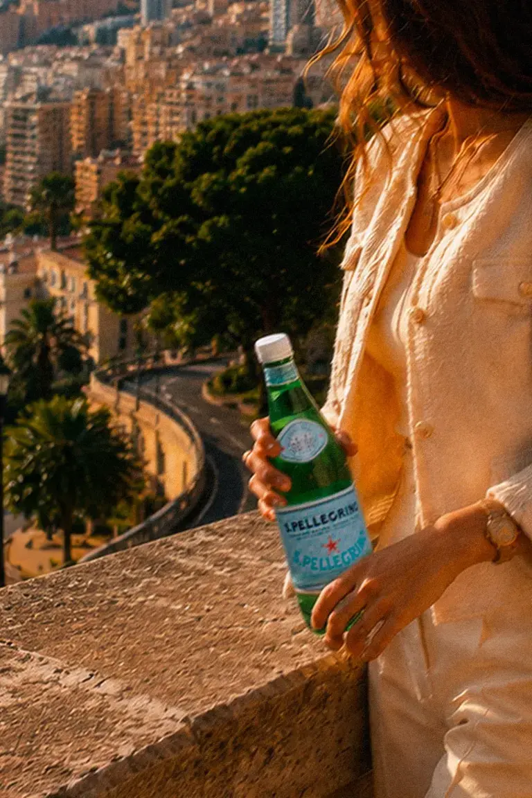 Woman holding a bottle of S.Pellegrino in Monte Carlo.