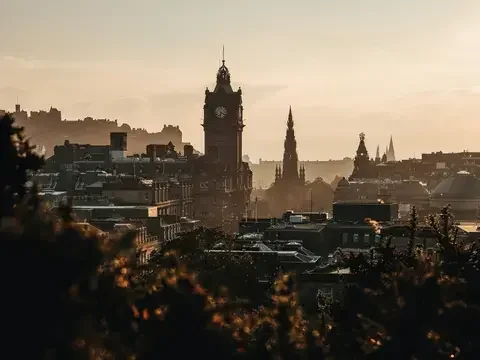 Edinburgh skyline at sunset, with the Balmoral clock tower, Scott Monument and the city’s medieval charm in warm golden light