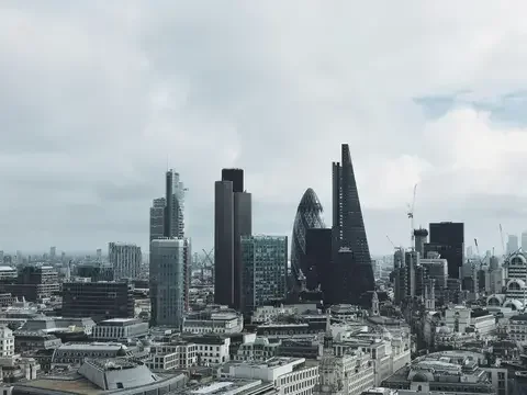 London’s iconic skyline with The Gherkin, The Cheesegrater, and modern skyscrapers rising under a cloudy sky