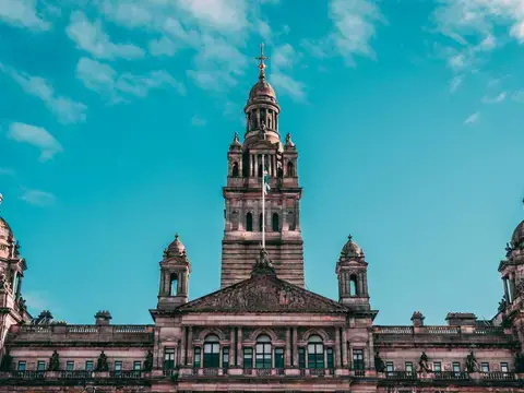 Ornate building with towers and sculptures, set against a bright blue sky, showcasing intricate architectural details