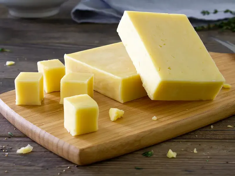 Cheddar cheese on a board.