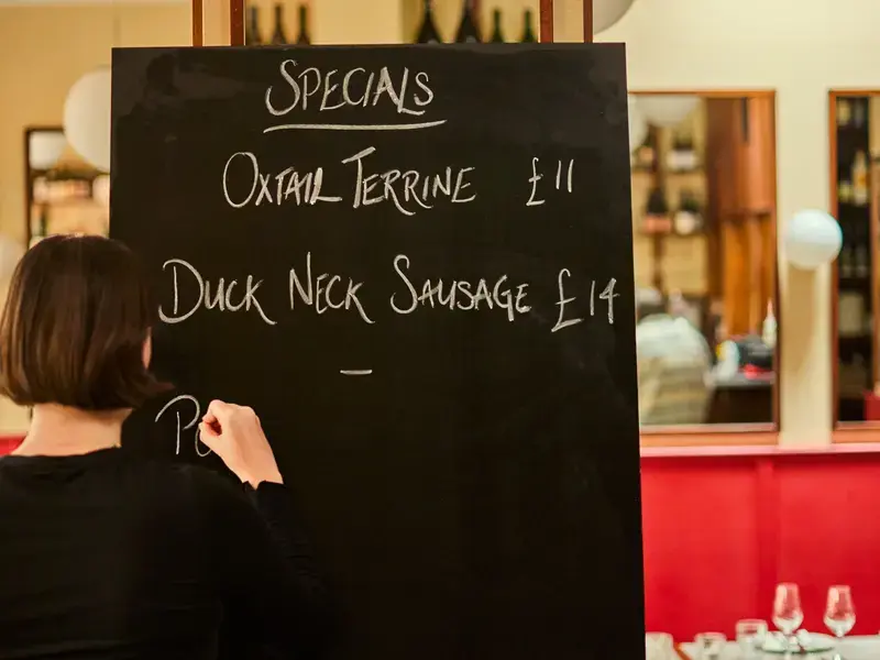 A woman writing on the blackboard at Camille.