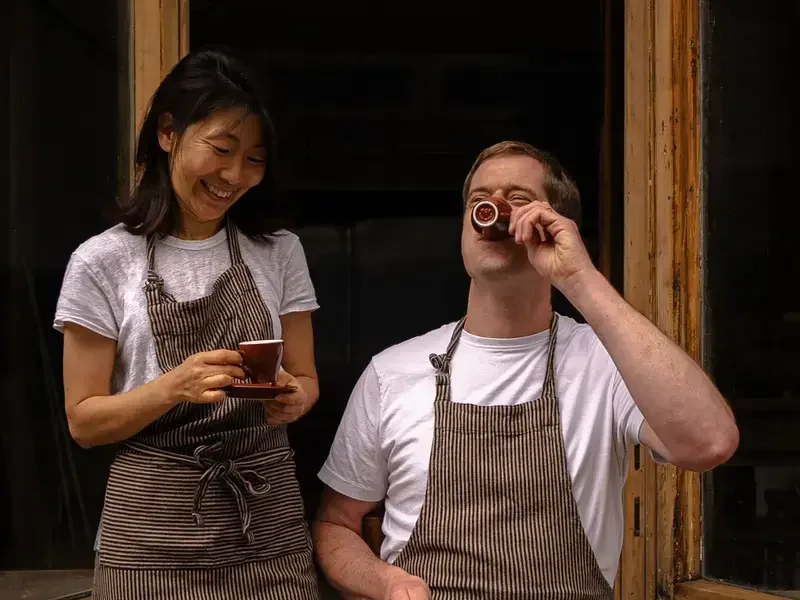 Kyu Jeon and Duncan Robertson drinking coffee.
