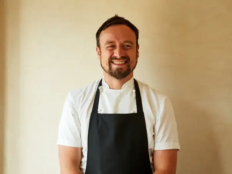 Chef Sam Carter smiling in an apron
