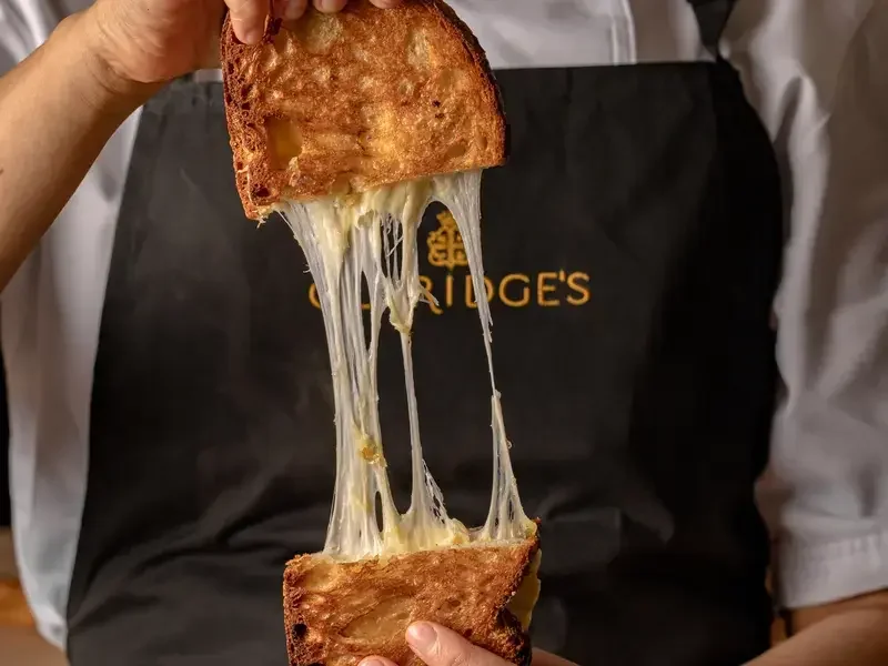 Someone pulling apart a toastie at Claridge's Bakery.