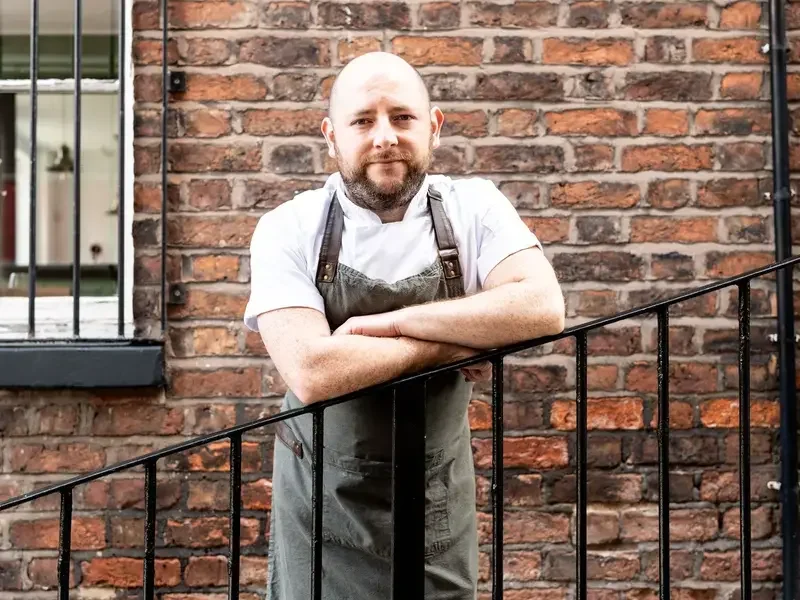 Chef Dan McGeorge leaning on a railing.