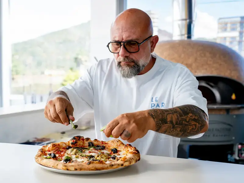 Chef Giuseppe Pignalosa placing toppings on a capricciosa.
