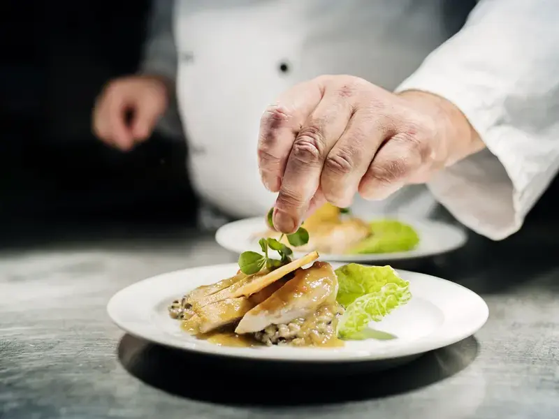 A chef putting the finishing touches to a dish.