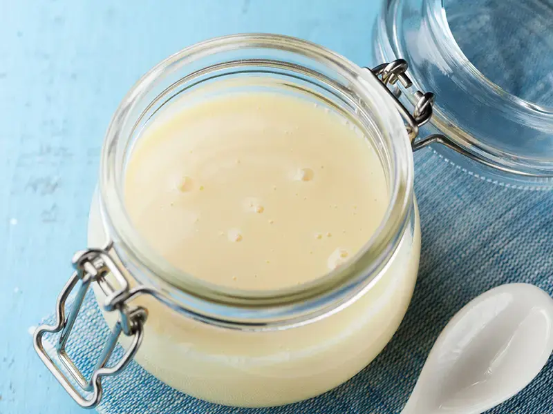 Condensed milk in a glass jar.