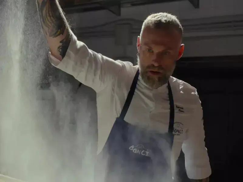 A man dusting flour from a height.