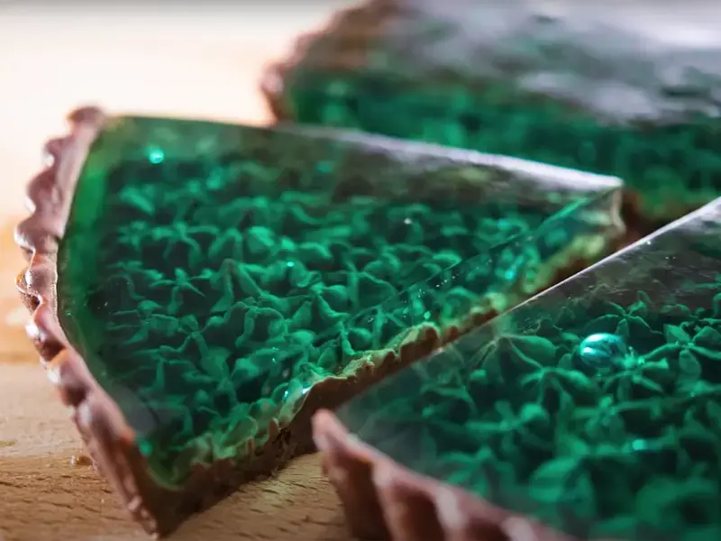 a slice out of a transparent green chocolate tart