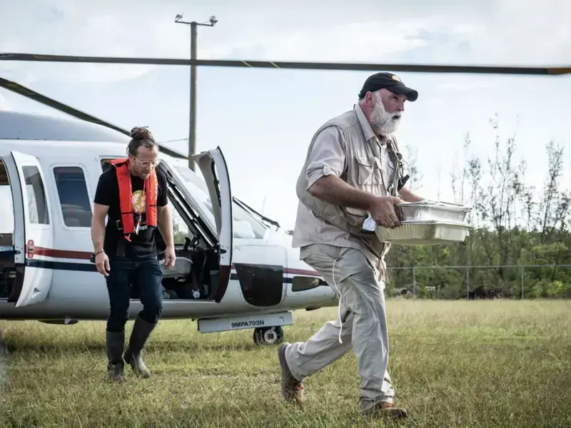 Jose Andres and another man running from a helicopter